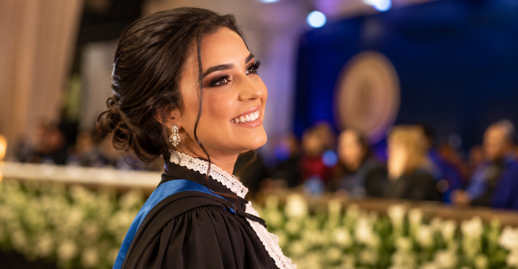 Formanda sorrindo com maquiagem finalizada em cerimônia de formatura